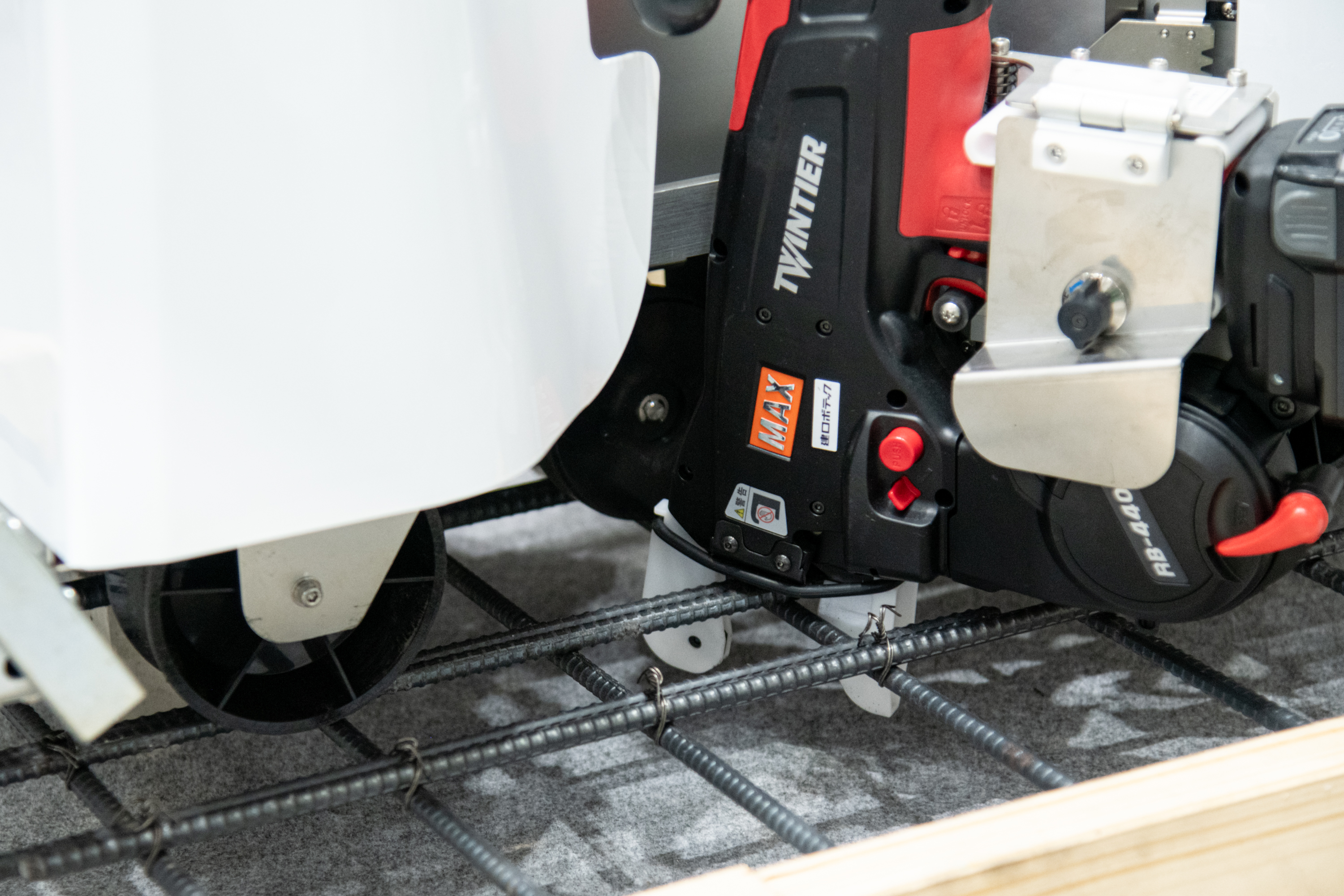 鉄筋結束機が鉄筋の交点を挟み、斜めにワイヤーで結束する。